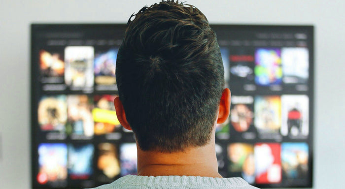 man staring at netflix screen with paranoia 